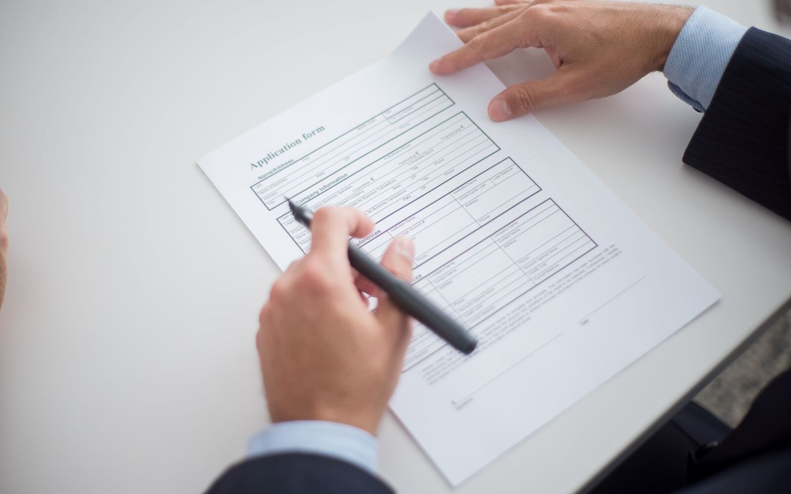 Personne remplissant un document papier au stylo