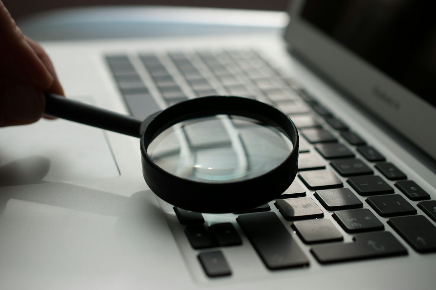 Mots-clés SEO : une loupe posée près d’un ordinateur portable
