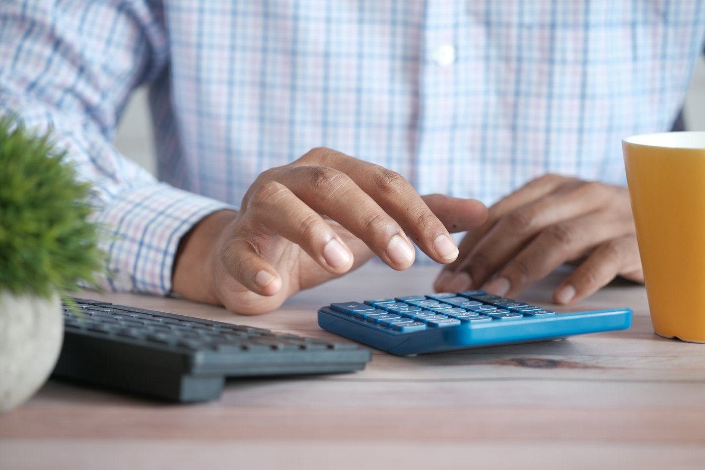 Prix du référencement naturel : une personne calcule un budget avec une calculatrice sur son bureau